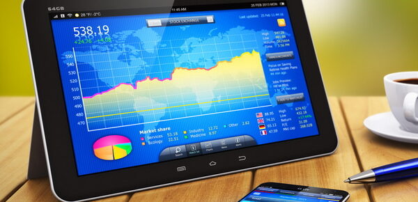 Tablet displaying bar graph placed next to cup of coffee, ballpoint pen and smartphone